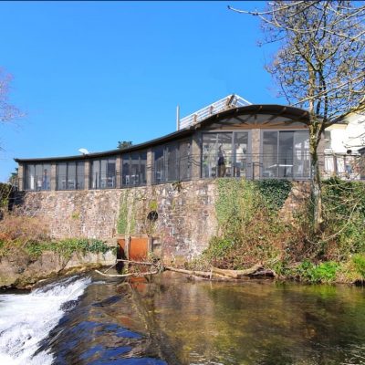 Rochelle's River Cafe: A stylish waterfront restaurant designed by MHM Design Ltd. and managed by iGroup South West Ltd., featuring outdoor seating with scenic river views.