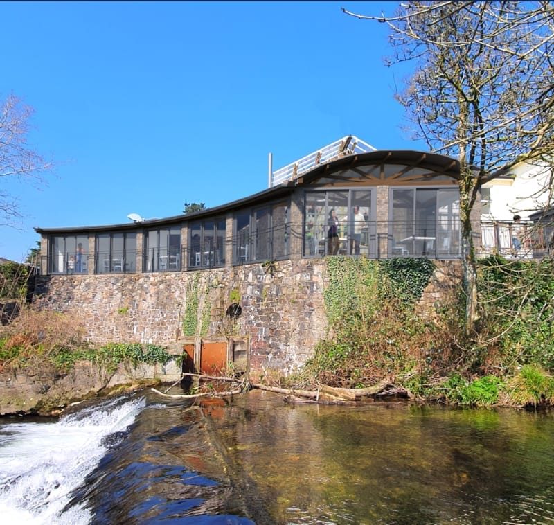 Rochelle's River Cafe: A stylish waterfront restaurant designed by MHM Design Ltd. and managed by iGroup South West Ltd., featuring outdoor seating with scenic river views.